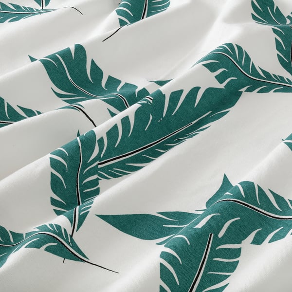 White curtains with large green leaf patterns, crisp and vibrant print, hanging neatly.
