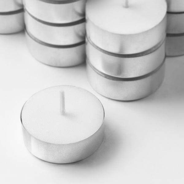 Group of sleek, modern white tealights in metal holders, neatly arranged.