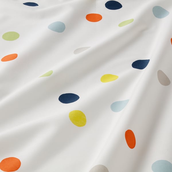 Brightly coloured teardrop patterns on soft, white bedsheet. Spotlight casts gentle shadows, highlighting durable and smooth fabric texture.