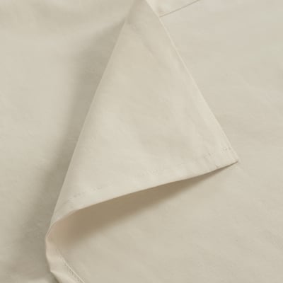 A crisp, white cotton fabric showcasing precise stitching along its edge. The material appears smooth and neatly folded.