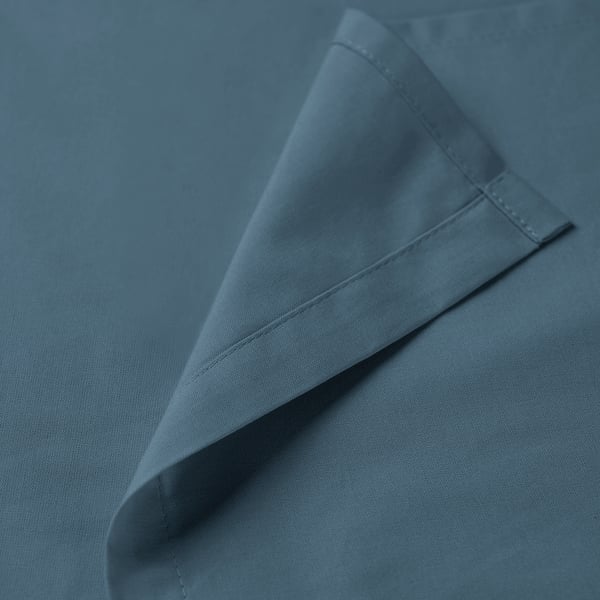 A close-up of a neatly folded blue cotton fabric, showcasing precise stitching and smooth texture.
