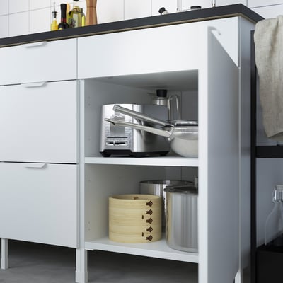 White kitchen cabinet with microwave and storage.