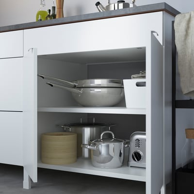 Kitchen cabinet with two shelves holding pans and toaster, designed for built-in hob.