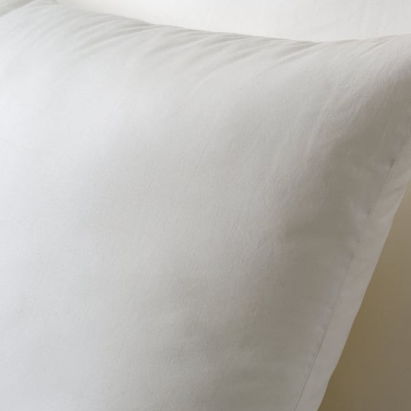 A close-up of a soft, white cushion with smooth fabric, showcasing its plush texture and support quality.