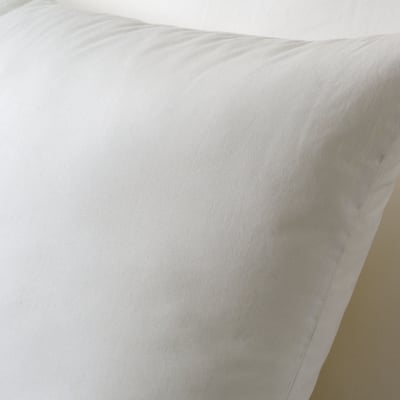 A close-up of a soft, white cushion with smooth fabric, showcasing its plush texture and support quality.