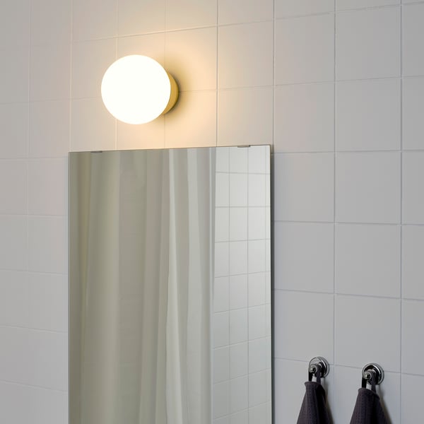 Modern bathroom light above mirror with towel hooks.