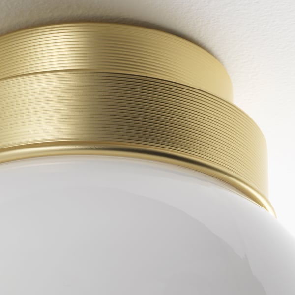Golden, ribbed ceiling light with glass shade. Modern design.