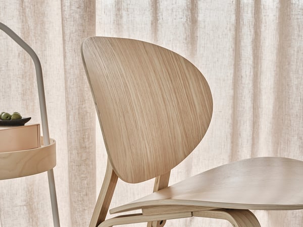 Light wooden chair, sleek modern design. Natural finish, curved back.