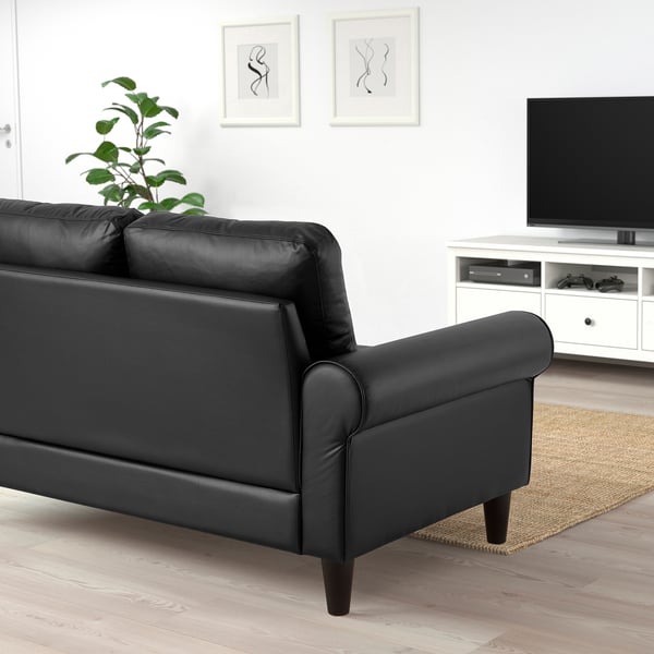 Modern living room with black GAMMALBYN sofa, tv, and plant.