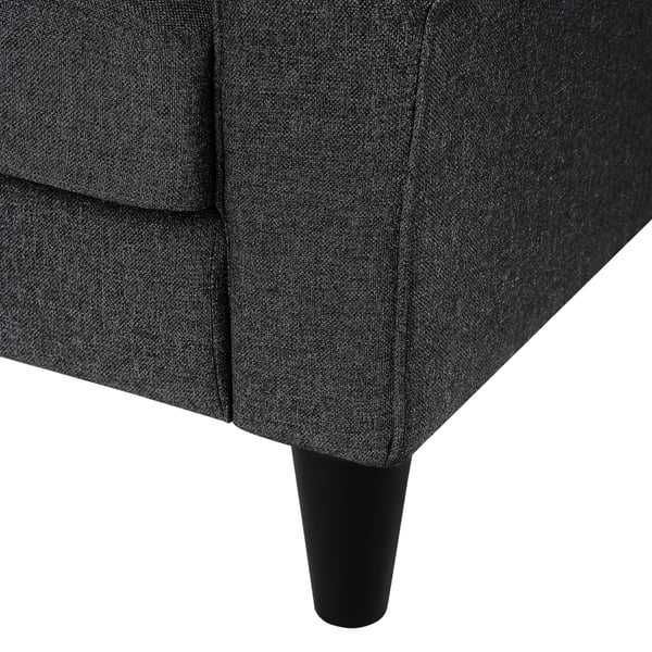 Dark grey upholstered sofa corner with tapered black legs, showcasing sturdy construction and quality fabric.