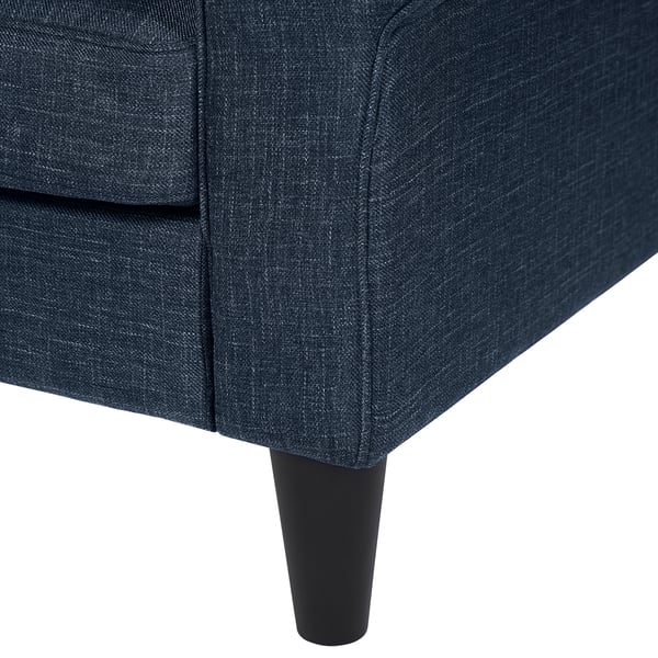 Dark blue upholstered sofa corner, showing plush cushions and sleek black wooden legs, highlighting quality comfort and design.
