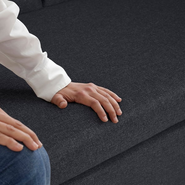 Hand on GAMMALBYN sofa bed, showing comfort and easy conversion.