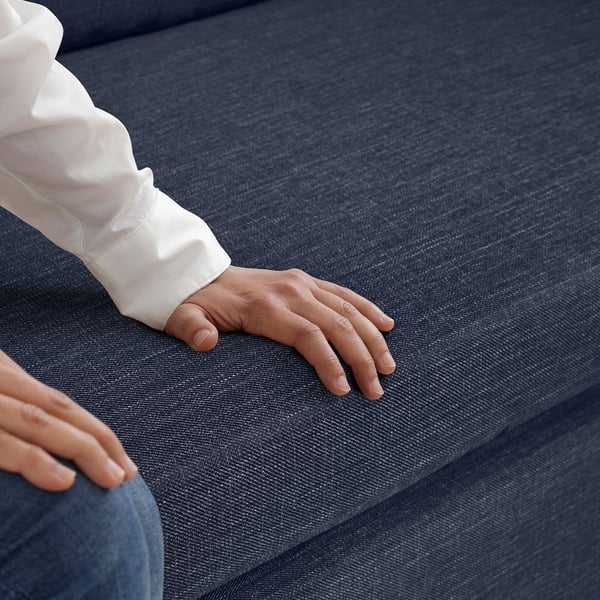 Hand resting comfortably on supportive, textured fabric surface of GAMMALBYN sofa-bed, showcasing soft yet firm material quality.