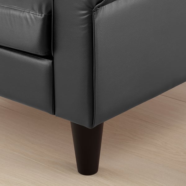 Black couch on wood floor.
