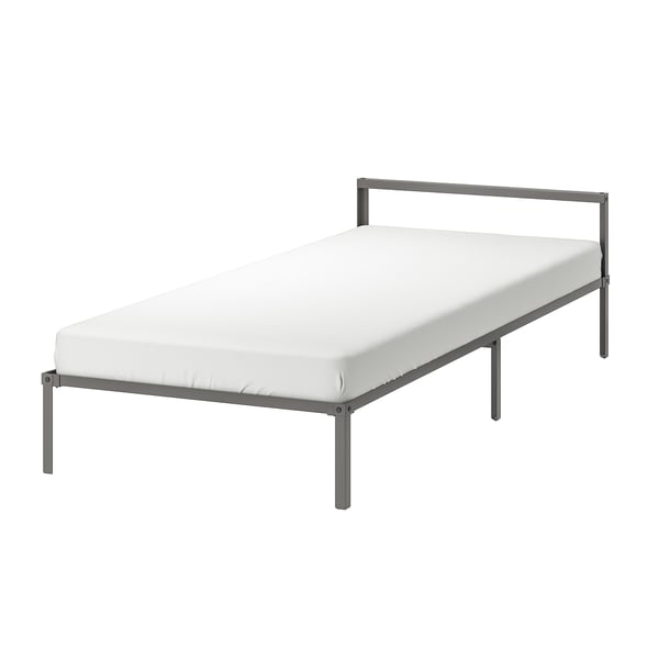 A GRIMSBU bed in grey with a white mattress, featuring a minimalist design with a metal frame and slatted base.