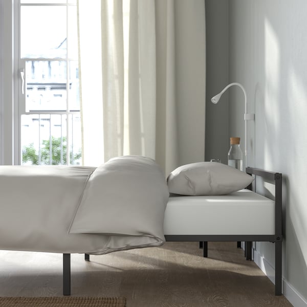 Bedroom with GRIMSBU bed, low-profile metal frame, under-window design, storage space under bed, clean and minimalist style.
