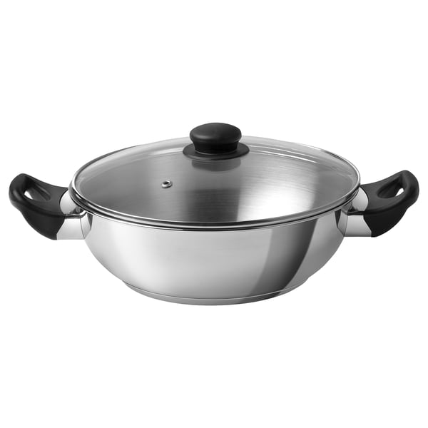 Stainless steel wok with glass lid, black handles, flat base, sloping sides.