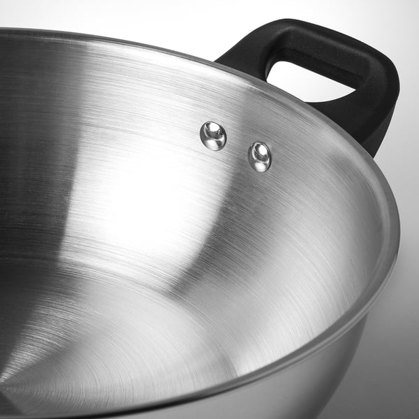 Stainless steel wok with black handle and two rivets, showcasing high-quality craftsmanship and durable design.