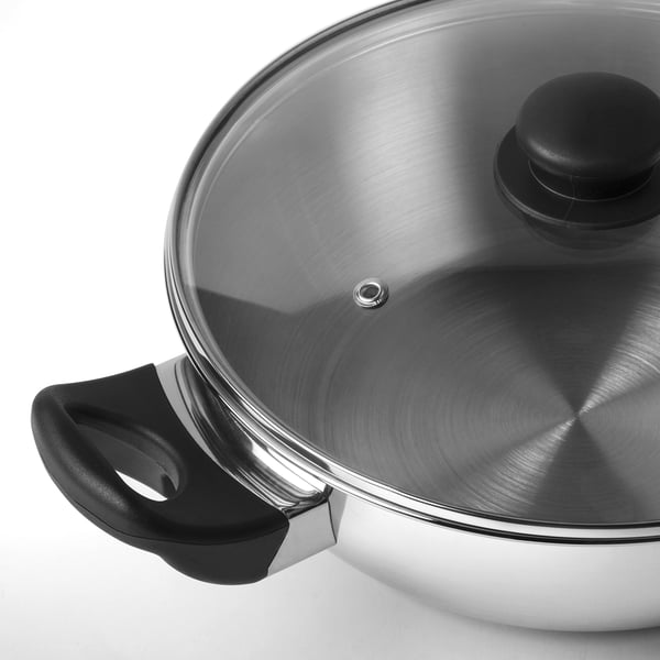 Stainless steel wok with secure black handles and glass lid, designed for durability and even heating.