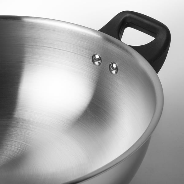 Polished stainless steel wok with sturdy black handle; sleek, reflective surface.
