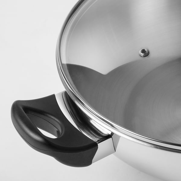 Stainless steel wok with glass lid and black handle. High quality, durable, and easy to clean. Ideal for various hobs, including induction.
