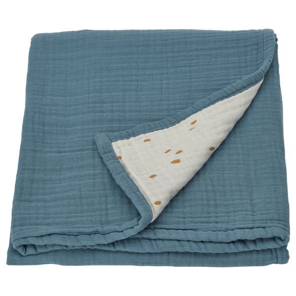 Folded blue baby blanket with white dotted side, made of organic cotton.