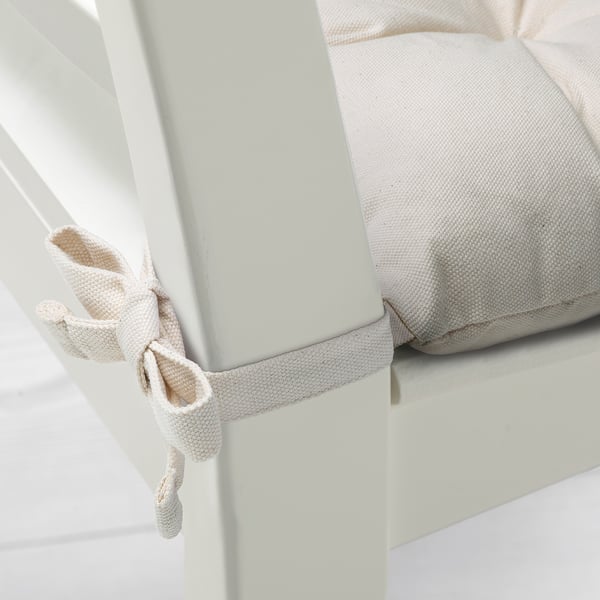 A chair pad with tied fabric edges, offering extra cushioning.