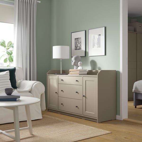 Sage green living room with grey sideboard, abstract art, and cosy decor.