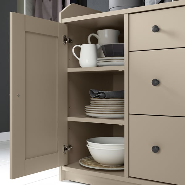 Beige HAUGA cabinet with open doors, showing dishes and bowls on shelves.
