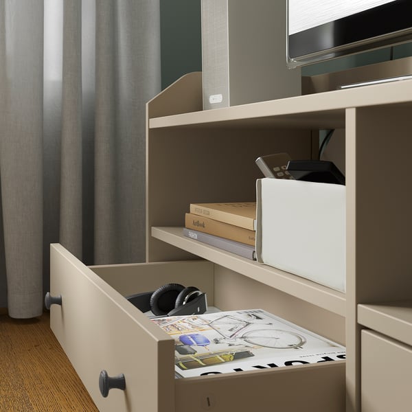 Light wood tv unit with drawers and shelves. Holds books, tech, and remote controls.