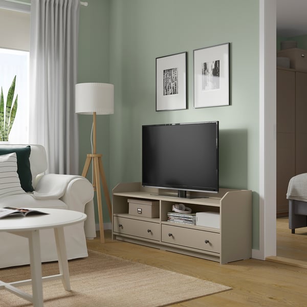 Modern living room with a HAUGA tv stand in beige, featuring a flat screen tv, drawers, and wooden floor.