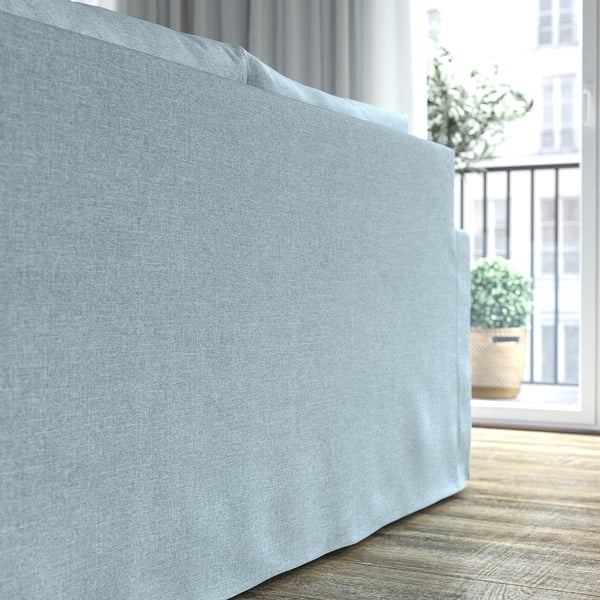 Light blue sofa with a sleek, classic design, positioned near a window with potted plants outside, offering a cosy and inviting seating area.