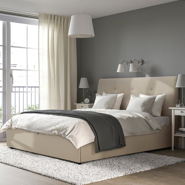 Beige IDANÄS upholstered bed with large headboard and grey/white bedding.