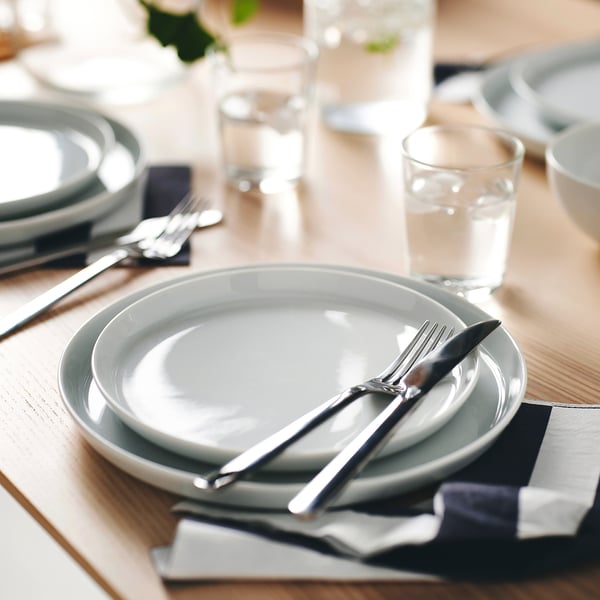 A table setting with two stacked plates and cutlery, ready for dining.