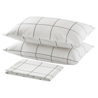Three white pillows with black grid lines, two stacked and one folded, minimalist bedroom decor.