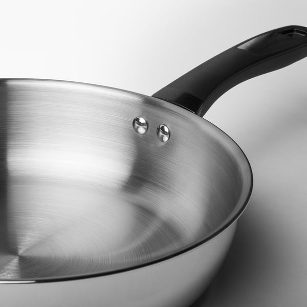 Stainless steel frying pan with black handle. Quality brushed finish, robust design.