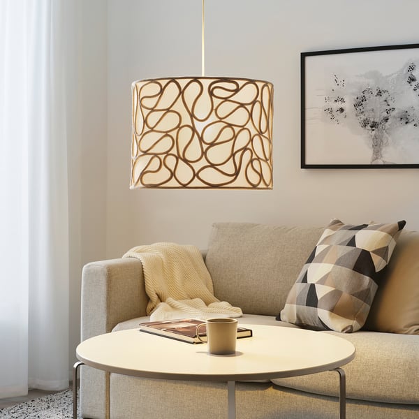 Cosy living room with KNOPPSLINGA lamp, wooden table, sofa & abstract art.