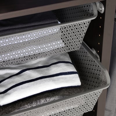 Metal wardrobe basket holding folded clothes, keeping items organised and air-circulating.