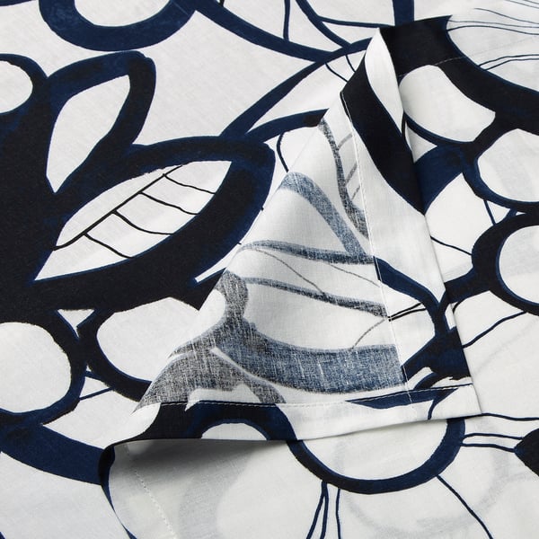 Abstract fabric with bold, black, circular patterns on light background. High-quality cotton with visible stitching.