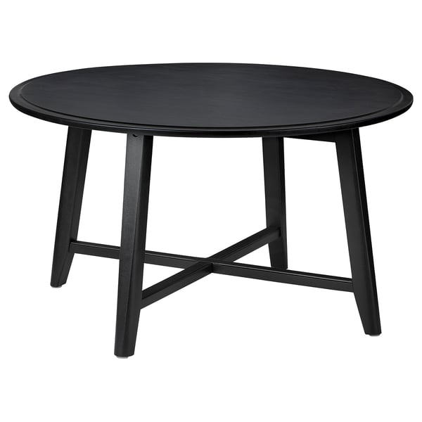 Black round KRAGSTA table, solid mango wood, four angled legs.