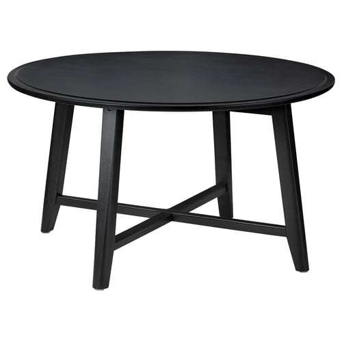 Black round KRAGSTA table, solid mango wood, four angled legs.