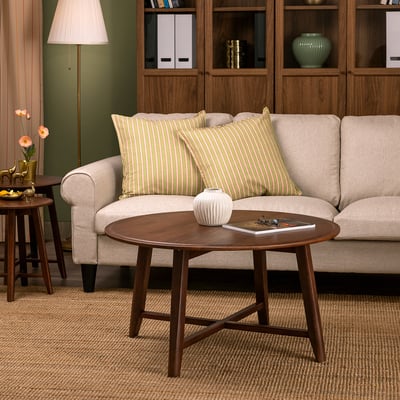 KRAGSTA brown coffee table, round & wooden, fits well beside beige sofa.