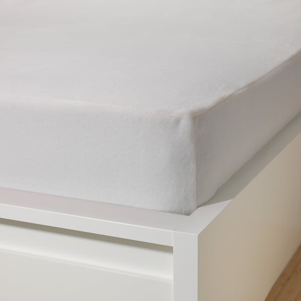 A thick, fleece bed sheet set seen on a white bed frame. The soft, warm material ensures comfort and fits up to 26 cm thick mattresses.
