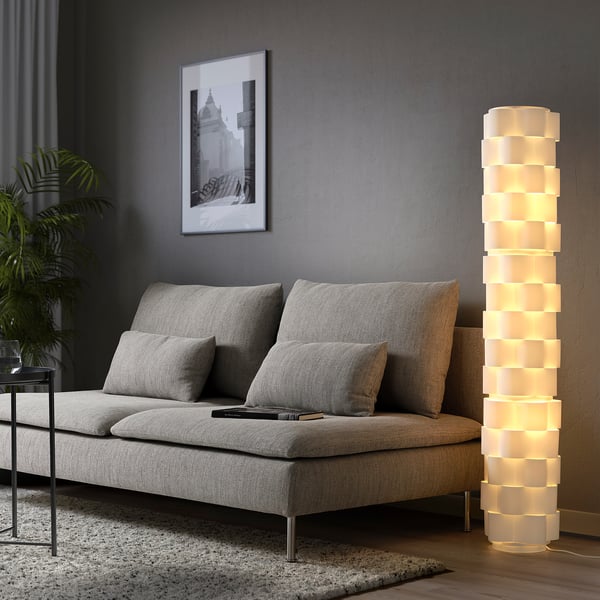 Modern living room with LÅGTRYCK floor lamp, grey sofa, side table, plant, and wall art.