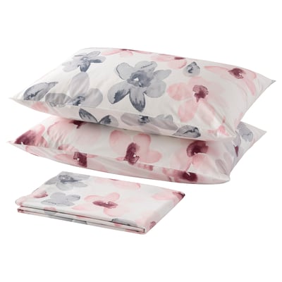 Neatly arranged pink and grey floral pillows and sheet for cosy decor.