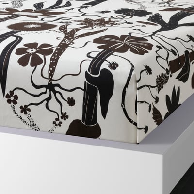 Black-and-white floral bedsheet set on white platform. Soft cotton/lyocell blend with large flowers.