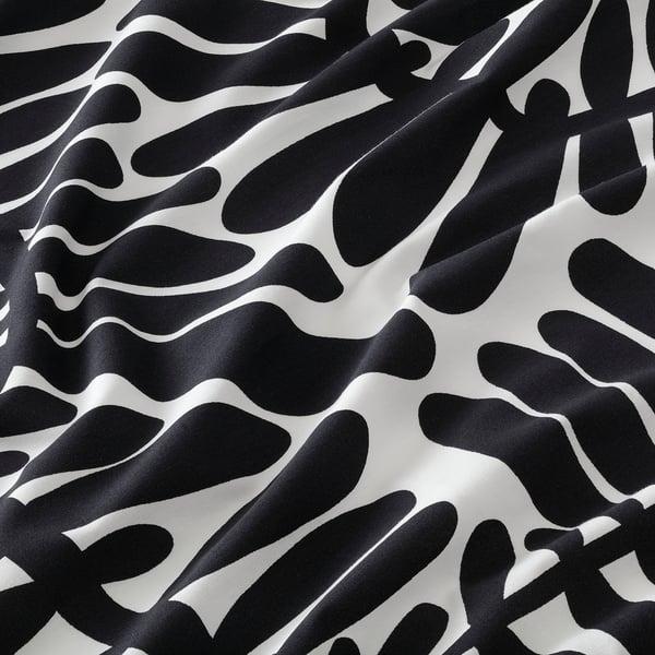 Abstract pattern of fluid black shapes on white background, smooth fabric texture visible.