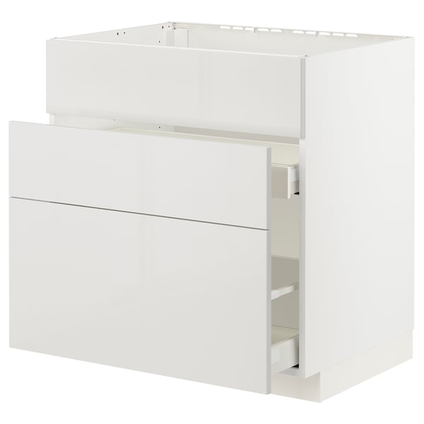 A white METOD kitchen cabinet with high gloss, smooth drawer fronts. It has a sleek, modern design with a clean, minimalist look.