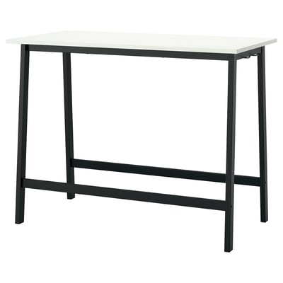 An MITTZON high conference table with a white top and black metal legs, designed for sitting or standing with built-in footrests.
