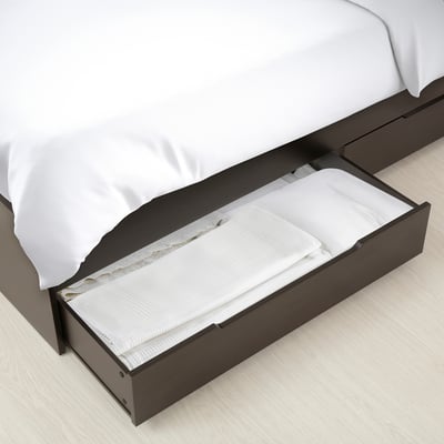 Under-bed storage drawers with folded bedding, showcasing efficient space utilisation.